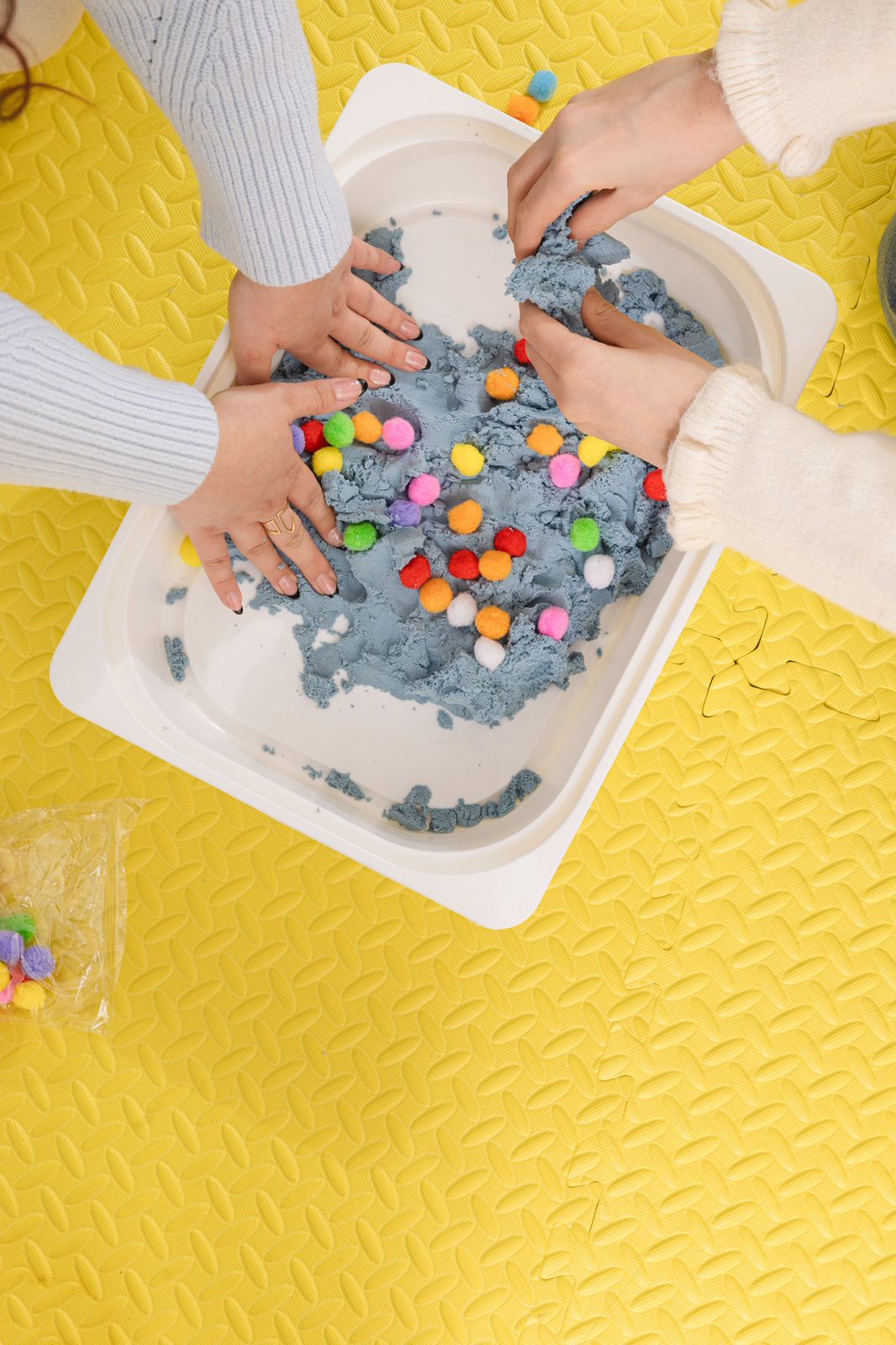 Occupational therapist guiding a child through fine motor skill exercises with colorful toys